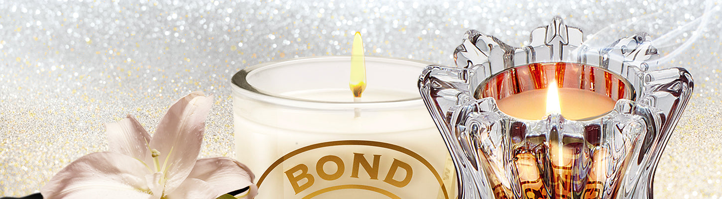 Candle with 'BOND' branding in a decorative holder on a glittery background