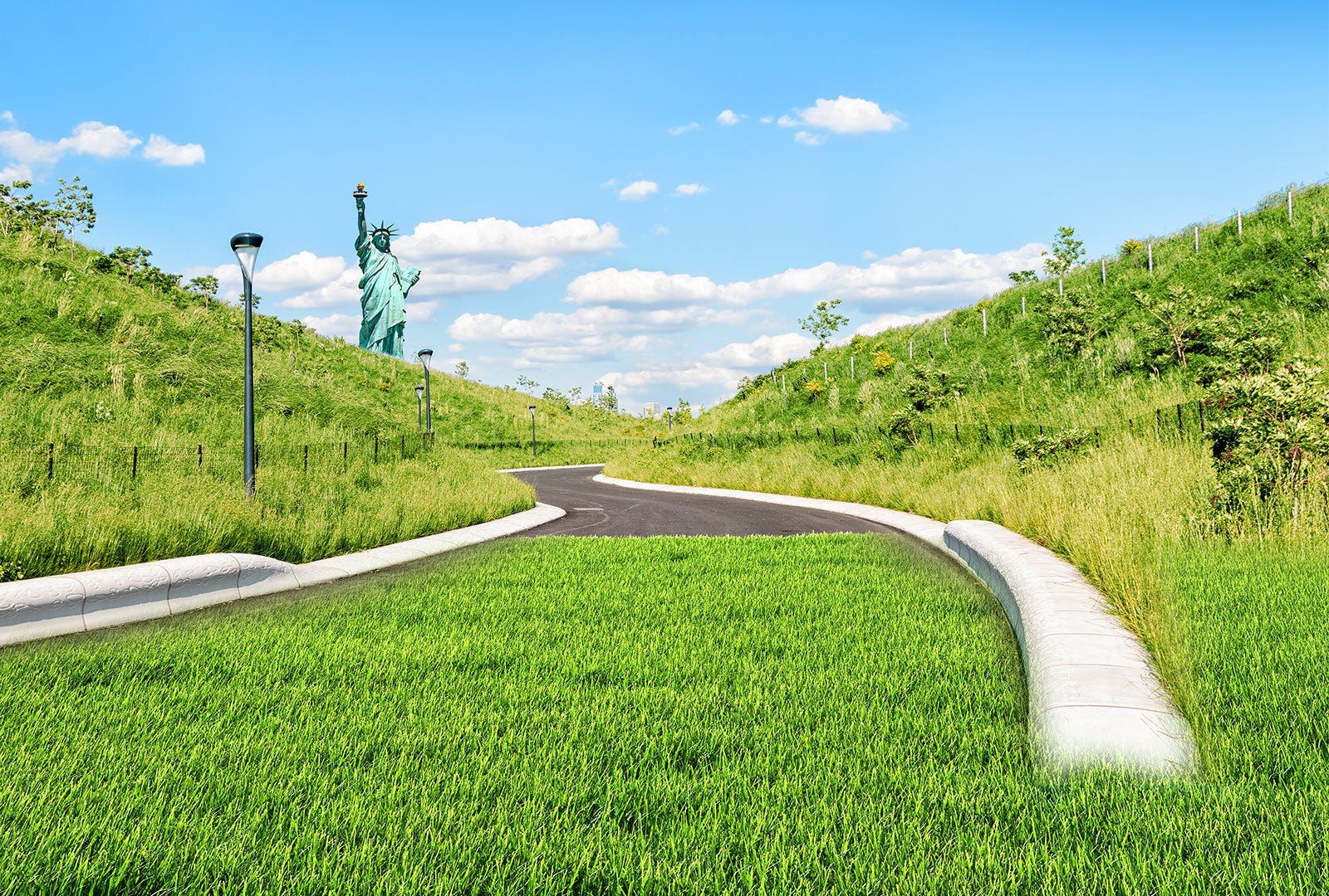 Statue of Liberty on a grassy hill with a clear blue sky