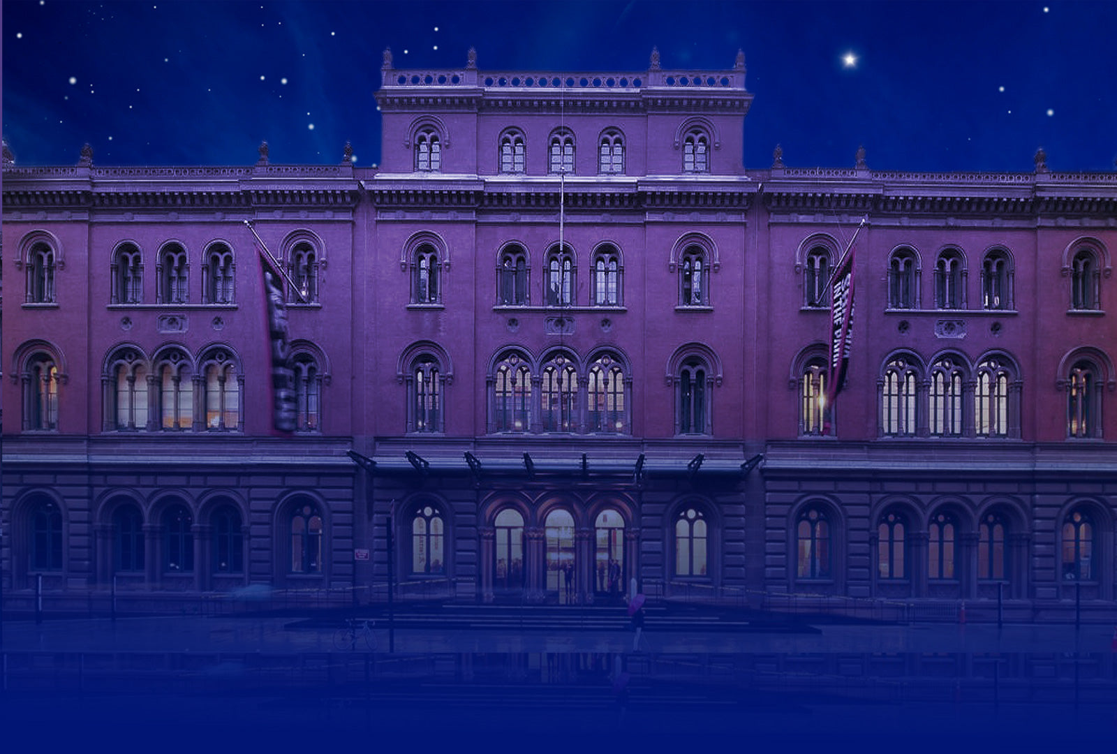 Large building with classical architecture under a starry night sky.