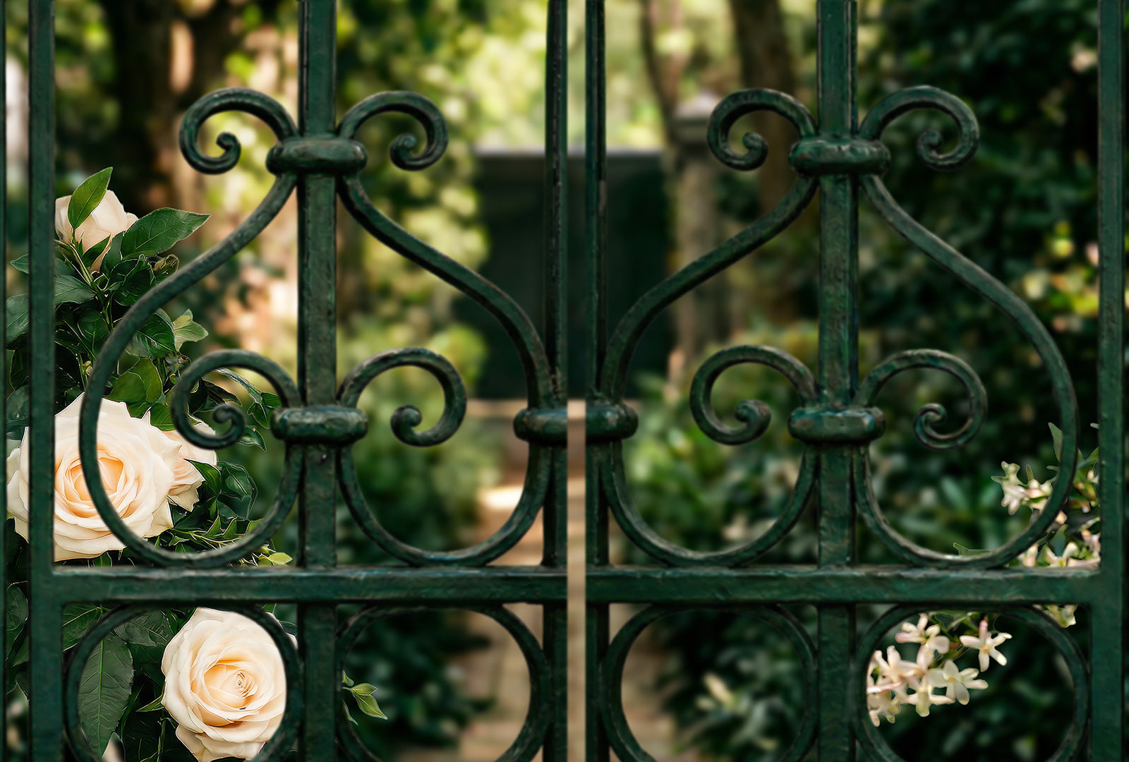 Decorative green metal gate with flowers in a garden setting