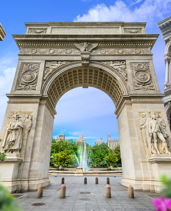 Stone archway with statues and a fountain in the background