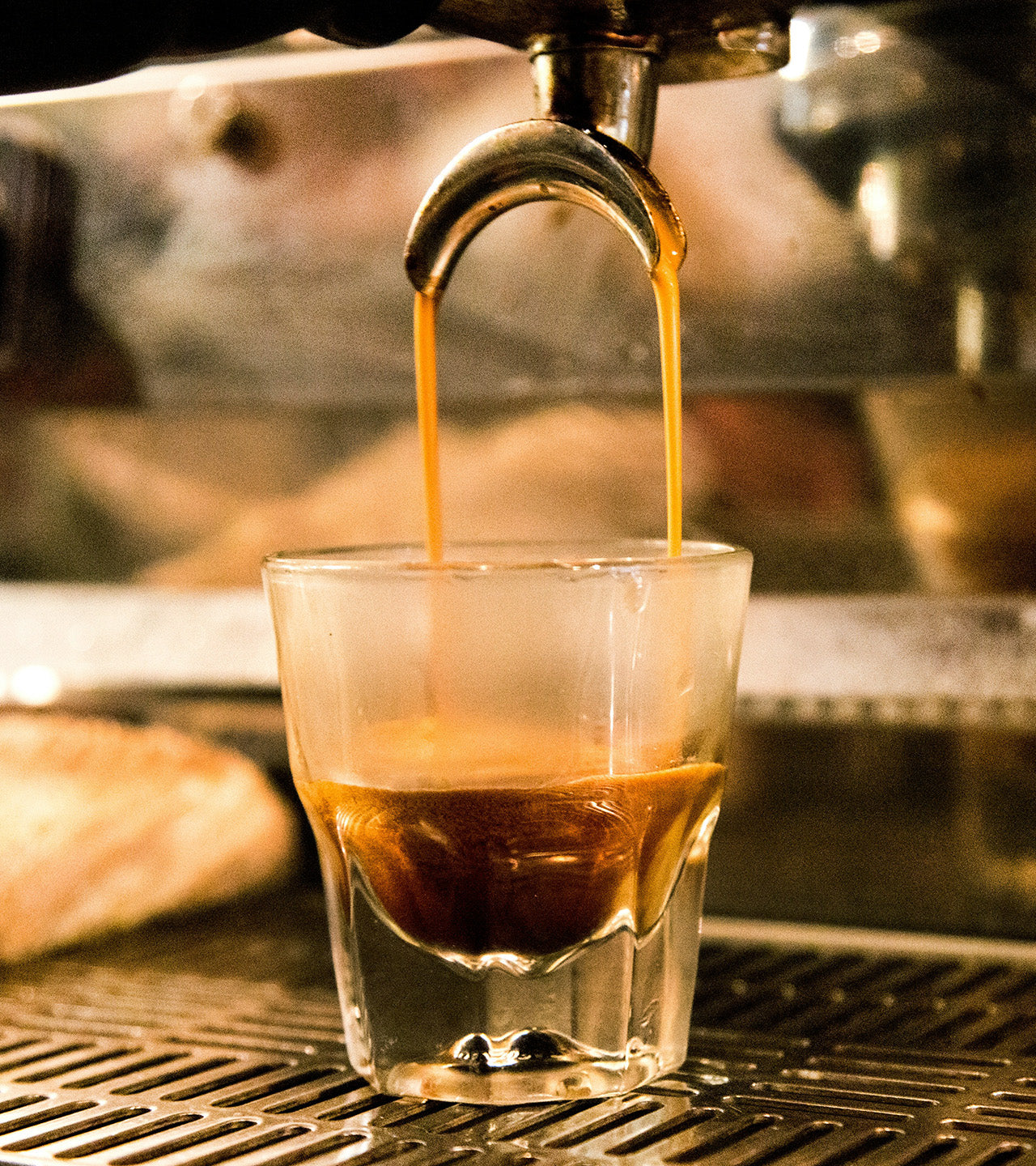 Espresso being poured into a glass from an espresso machine.